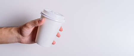 white paper Cup in hand, mockup, copy space, banner, disposable packaging conceptの写真素材