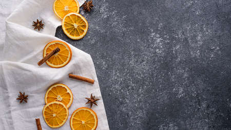 festive new year kitchen background, dried orange slices, cinnamon sticks, star anise on white towel...