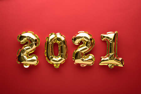 gold foil balloons numbers 2021 on red background, christmas composition, concept, top view, flat layの写真素材