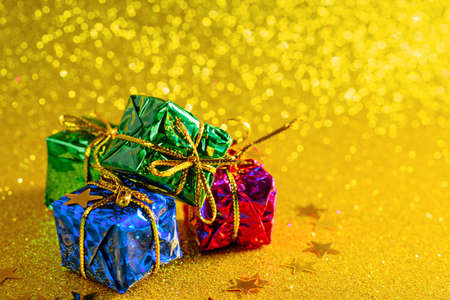 gift boxes on gold shiny background, copy space, christmas composition