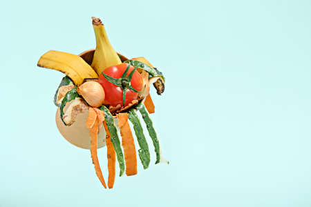 compost, food trash, vegetable peels in compost bin on blue background, Copy space, levitation