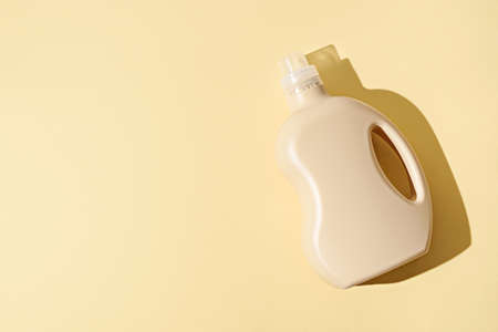 empty plastic beige container, bottle on yellow background, mock up, copy spaceの写真素材