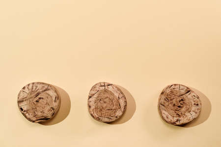 three round wooden boards on beige background, top view, copy space, eco backgroundの写真素材