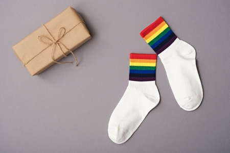 pair of white socks with rainbow edging and gift box on gray background, idea for gift lgbt friends,...