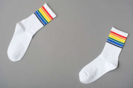 top view white cotton socks with rainbow colors on gray background, LGBTQ symbol, gift idea to LGBT...