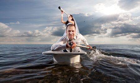 The bride and groom are sailing in the sea on a honeymoon の写真素材