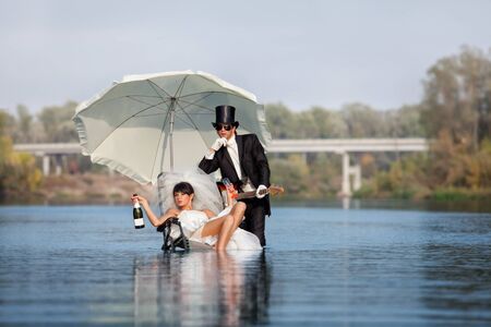 Young married couple with guitar and champagneの写真素材