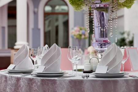 Seating card for wedding table. Wine glasses with napkins set in restaurant.の写真素材