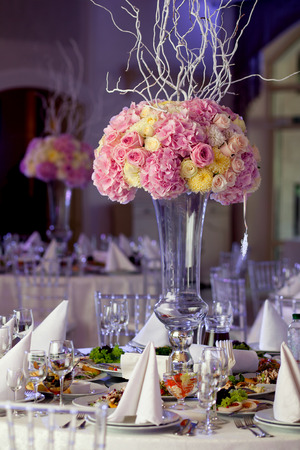 Table setting at a luxury wedding reception. Beautiful flowers on the table.の写真素材