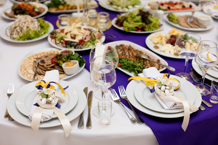 Wine glasses on table with other eating utensilの写真素材