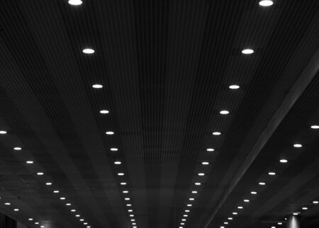 Converging lines of lights on a striped ceiling