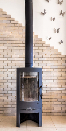 Fireplace in modern interior with brick wall and steel butterflies on the wall Israel.のeditorial素材