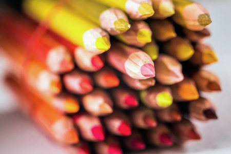 Assortment of colored drawing pencils in a variety of red shades shot with shallow deapth of field.の写真素材