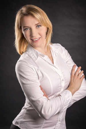 Modern business smiling woman portrait, wearing classic white shirt and black pant studio shot.の写真素材