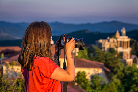 Girl taking of areal view photo at the sunset from high mountain of the Signaghi, Georgia.の写真素材