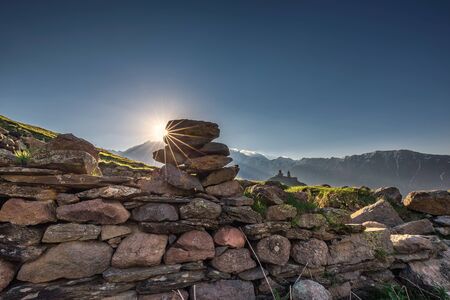Gergeti Trinity Church also known as Tsminda Sameba on the background of a mountain ridge and clouds, Stepantsminda, Kazbegi, Georgia.の写真素材