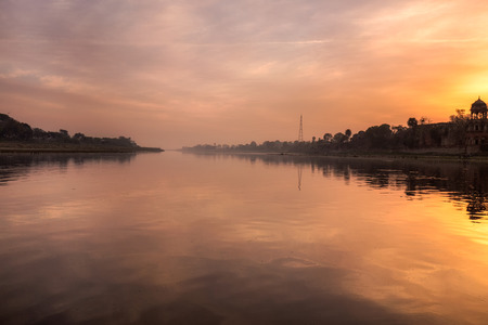 Taj Mahal shot from the boat at Yamuna river at sunset Agra, India.