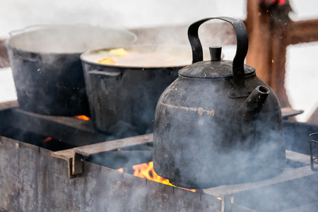 Iron coockware Ð°Ñ Shrovetide (Pancake week) festival with outdoor snow activities including: armwrestling, bag fighting, cubes moving at Dudutki, Belarus.の写真素材