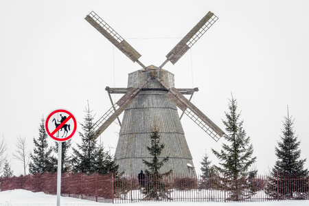 Wooden windmill under heavy snow and road sign to Don Quixote passage banned in Dudutki, Belarus, 25 kilometers away from Minsk.の写真素材