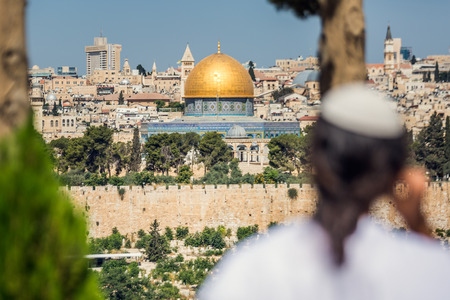 Religious man overlooking golden dome of
Temple Mount and West Wall most important religious monument for jews and muslim in old town of Jerusalem.の写真素材