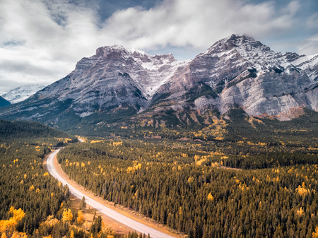 Kananaskis provincial park with lake, road, mountains and yellow autumn colored trees, Canada.の写真素材