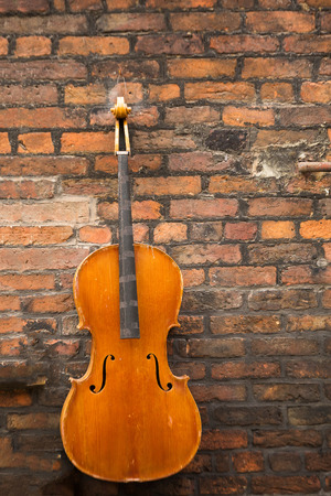 Decoration on the brick wall is a old violin, on the streets in Liverpoolの写真素材