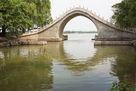 A Moon Gate Bridge - highly-rounded arched pedestrian bridge. The high arch and its reflection form a circle, symbolizing the moon.の写真素材