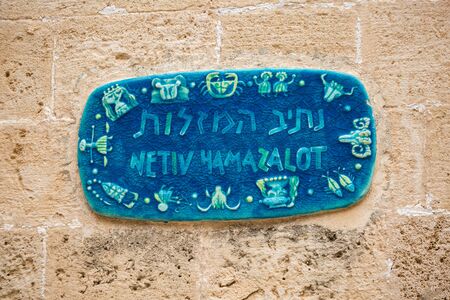 Tel Aviv, Israel - April 20 2018: Vintage tables with street names and ornaments on ancient stone houses in the old city of Jaffa in a warm Tel Avivの写真素材