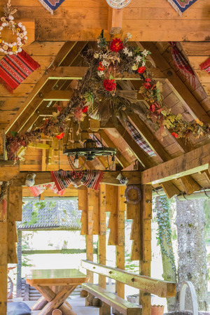 Local restaurant in Romania in a traditional style with a lot of interesting and traditional decor on the territory of a green park on a sunny dayの写真素材