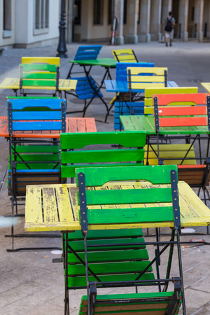 Bright chairs and tables stand on the terrace in cafes of different colors green, oranzhivye and blueの写真素材