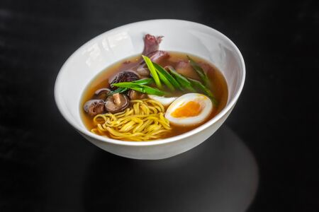 Ramen soup with an egg, homemade pasta, mushrooms and beef in the white plate.の写真素材