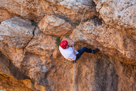 Acre, Israel - April 15 2018: Tourist rock climber climbs up the rock overcoming obstacles on a dangerous rock site in the north of Israelのeditorial素材