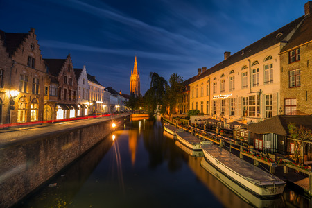 Bruges, Belgium - July 28 2018: Blue hour shot of historic medieval buildings along a canal in Bruges, Belgiumのeditorial素材