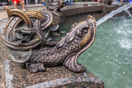 Bronze fountain fish with a stream of water in Kiev, Ukraine.の写真素材