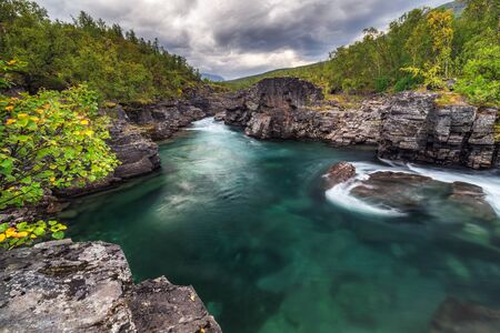 Cloudy fall autumn view of Abisko National Park, Kiruna Municipality, Lapland, Norrbotten County, Sweden, with Abiskojokk river and Nuolja mountain, near border of Finland, Sweden and Norwayの写真素材