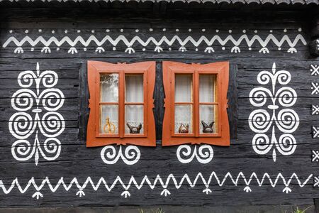 Old wooden houses in Slovakia village Cicmany in autumn. Unique decoration of log houses based on patterns used in traditional embroidery in village of Cicmanyの写真素材