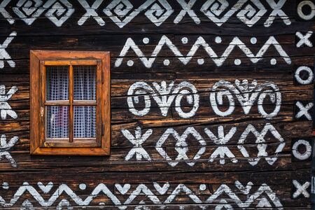 Old wooden houses in Slovakia village Cicmany in autumn. Unique decoration of log houses based on patterns used in traditional embroidery in village of Cicmanyの写真素材