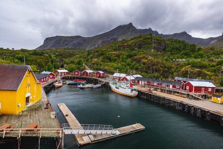 Traditional yellow wooden houses, rorbuer in the small fishing village of Nusfjord, Lofoten islands, Norway. Nusfjord, Norway - August 26 2019.のeditorial素材