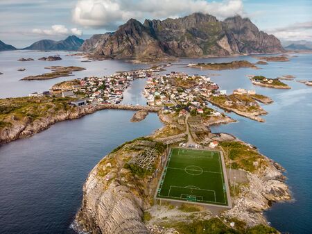 Incredible aerial view of Henningsvaer, its scenic football field and mountains in the background. A small fishing village located on several small islands. Henningsvaer, Norway - August 24 2019.のeditorial素材