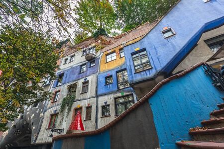 Hundertwasser house, Hundertwasserhaus - apartment house, idea and concept of Austrian artist Friedensreich Hundertwasser. Colorful facade with growing autumn trees. Vienna, Austria - October 20 2019.のeditorial素材