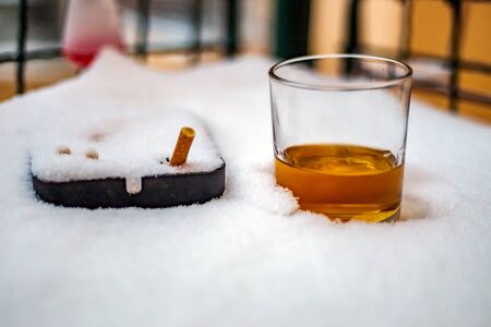 Frozen winter landscape of Plitvice Lakes under heavy snow, Croatia. Stands in the snow glass with whiskey and ashtray.の写真素材