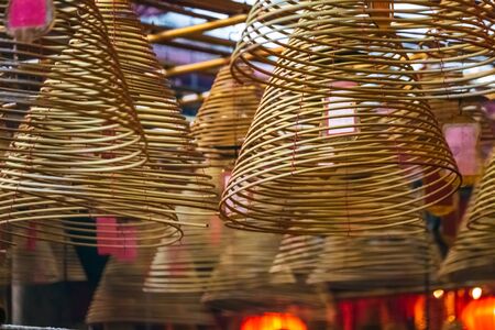 Interior of Man Mo Temple in Hong Kong with incense offerings and coils suspended from the ceiling at Hong Kong.の写真素材