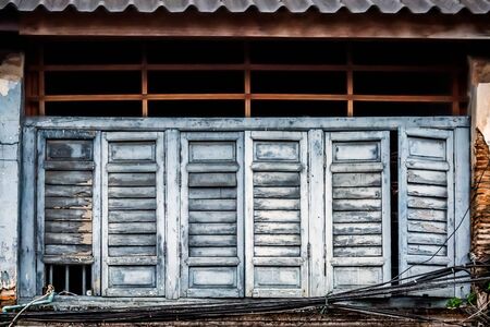 Wooden shutters on the windows in different shapes. Colorful buildings in old Phuket town in Thailand. Sino Portuguese style.の写真素材
