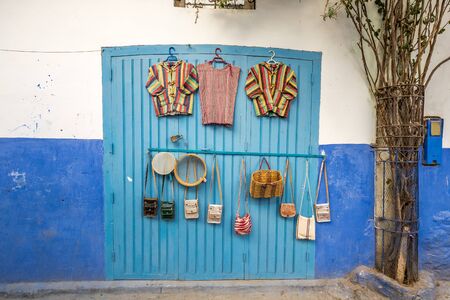 Local items for sale with colorful wooden doors at famous blue city of Chefchaouen, Morocco.の写真素材