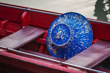 Blue hat in a boat at famous Pattaya Floating Market which has traditional rowing boats. Villagers sell traditional foods and souvenirs.の写真素材