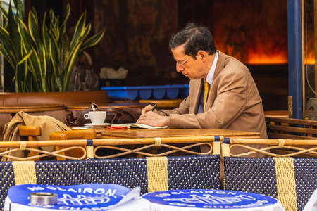 Man in the charming Cafe on Montmartre hill. Montmartre with traditional french cafes and art galleries is one of the most visited landmarks in Paris. Paris, France - July 28 2018.のeditorial素材