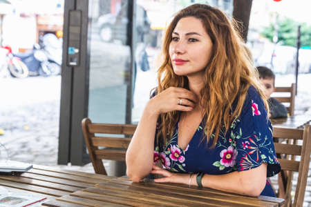 Girl sits in the charming cafe on Montmartre hill. Montmartre with traditional french cafes and art galleries is one of the most visited landmarks in Paris. Paris, France - July 28 2018.のeditorial素材