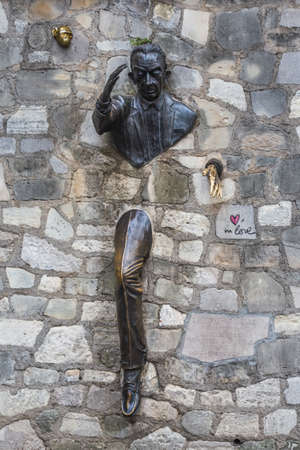 Bronze sculpture: man walking through the wall, based on the story of the same name, written by french writer Marcel Aime in 1943. One of the main sights of Montmartre.Paris, France - July 28 2018.のeditorial素材