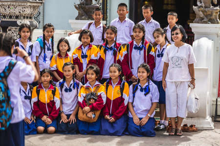 Thai group of children make photo near city pillar in school unoform Chiang Mai, Thailand - November 09 2017.のeditorial素材