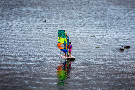 Father teaches his daughter to use windsurfing board in Auckland, New Zealand. Auckland, New Zealand - December 17 2017.のeditorial素材